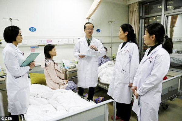 Tim dokter usai proses operasi transplantasi rahim memeriksa kondisi Yang Hua (duduk). 