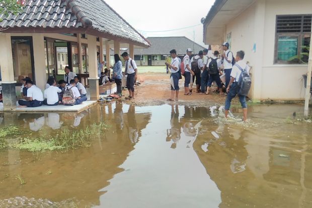 Siswa SMPN 3 Tirto Kabupaten Pekalongan, Jawa Tengah, terpaksa melaksanakan ujian nasional (UN) di tengah banjir, Selasa (2/5/2017). Foto/MNC Media/Suryono