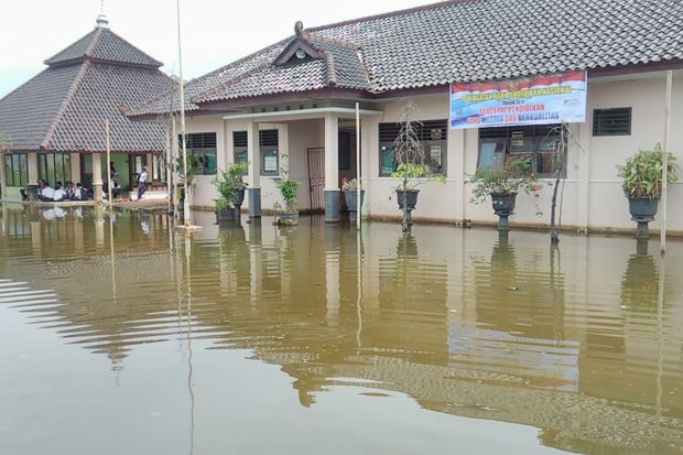 Siswa SMPN 3 Tirto Kabupaten Pekalongan, Jawa Tengah, terpaksa melaksanakan ujian nasional (UN) di tengah banjir, Selasa (2/5/2017). Foto/MNC Media/Suryono