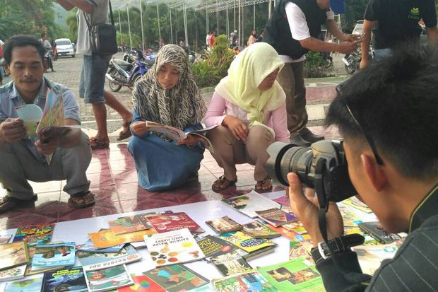 Para penggiat literasi di Lampung menggelar acara Ngabu Book Read di Menara Siger Lampung. Mereka menunggu waktu buka puasa sembari menebar virus baca. Foto/MNC Media/Heri Fulistiawan