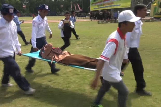 Pelajar yang pingsan saat upacara bendera di Alun-Alun Jombang, Jatim, dievakuasi petugas PMI. Foto/MNC Media/Mukhtar Bagus