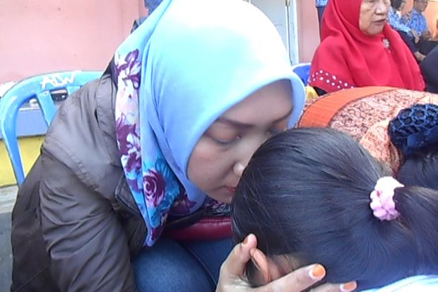Siswi SMPN 5 Purwokerto memeluk erat ibunya. Foto/MNC Media/Saladin Ayyubi