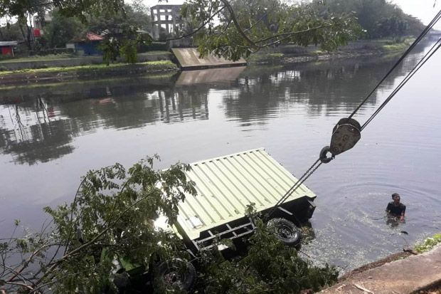 Tersangkut Batang Pohon, Mobil Boks Tercebur ke Kali Angke