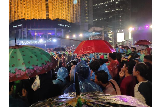 Diguyur Hujan, Warga Padati Bundaran HI untuk Rayakan Malam Tahun Baru